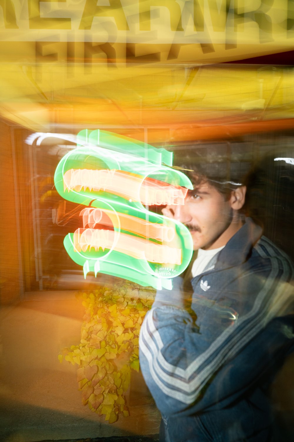 Ted Koller photographed through a neon sign.